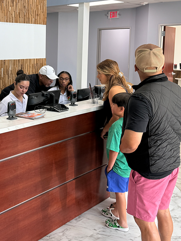 League City parents exercising while children enjoy daycare playroom.